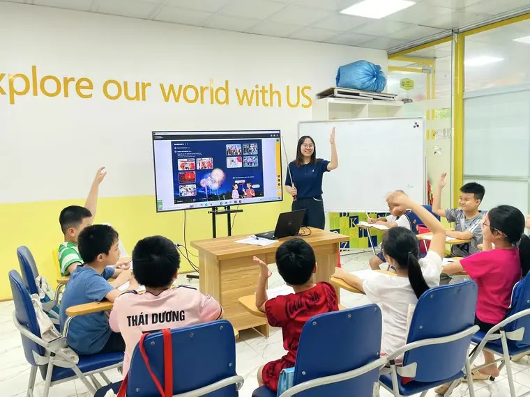 Giáo viên Clever Junior giảng bài, học viên giơ tay phát biểu trong giờ học