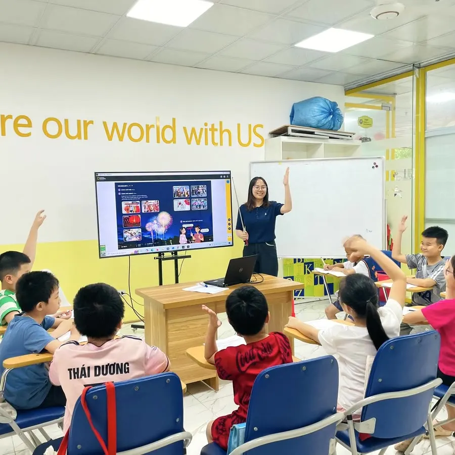 Giờ học tiếng Anh tại Clever Junior: học viên giơ tay phát biểu cùng giáo viên trong lớp