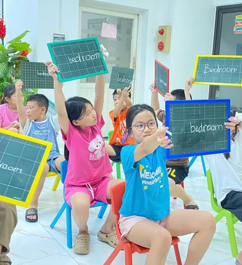 Học sinh Clever Junior giơ bảng ghi từ tiếng Anh trong giờ học
