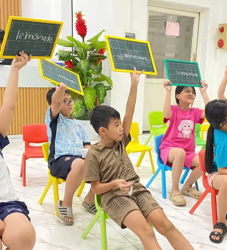 Học sinh Clever Junior giơ cao bảng ghi từ tiếng Anh trong giờ học